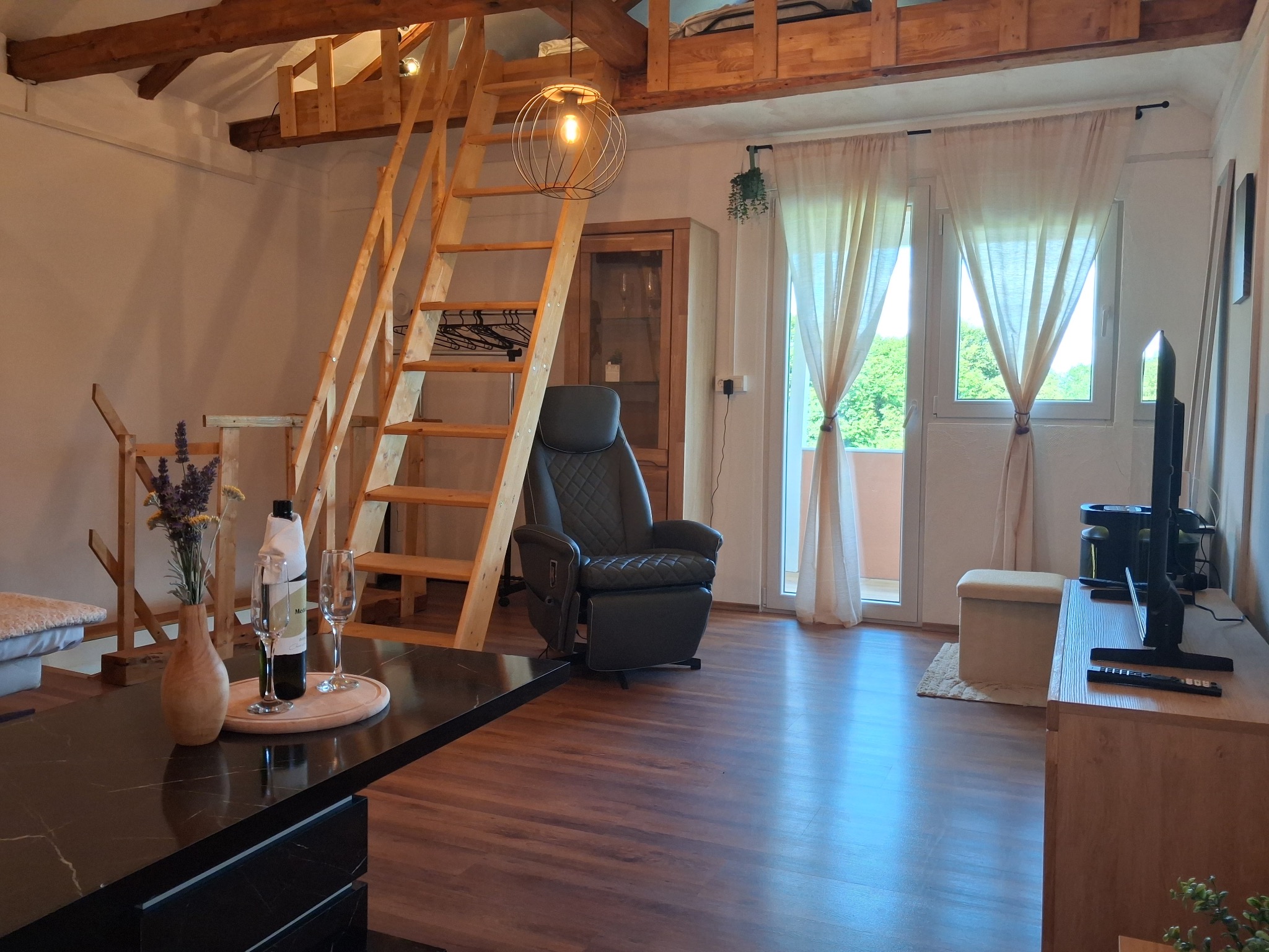 Wohnbereich mit Holztreppe und TV